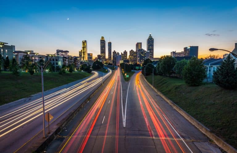 Atlanta skyline at dusk seen along a highway with traffic light trails